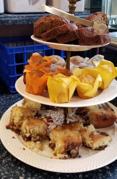A tiered cake stand displaying various baked goods, including loaf slices and colorful muffins.